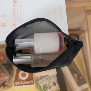 Detail of black mesh makeup bag showing interior storage capacity with beauty products