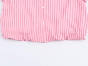 Dettaglio camicia a righe rosa con orlo elastico e bottoni bianchi in tessuto cotone