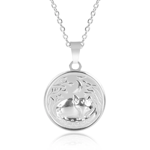Macro shot of silver stainless steel pendant with sleeping fox and crescent moon engraving
