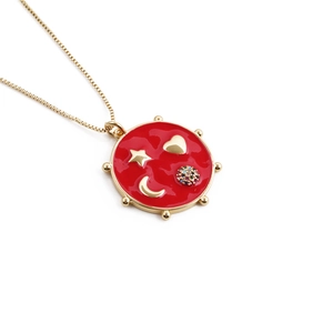 Golden necklace with red enamel round pendant featuring heart, star and moon charms