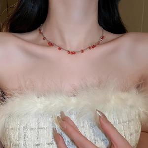 Gros plan d'un collier de perles argentées avec des cristaux rouges sur un mannequin