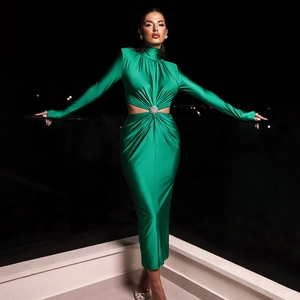 Détail de robe en satin vert avec découpe latérale et anneau décoratif à la taille
