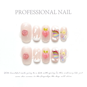 Detail of press-on nails featuring 3D peach designs, hearts, and rainbow hand-painted patterns