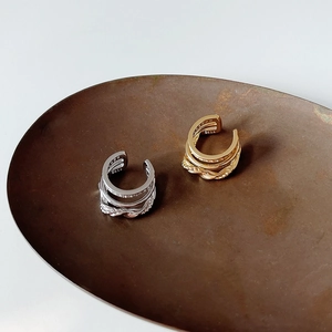 Close-up of S925 sterling silver triple-layer woven ear cuffs with textured gold and silver finishes