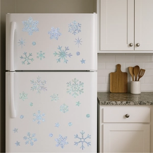 Detailed view of silver blue glitter snowflake stickers on a modern white refrigerator