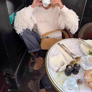 White bohemian knit sweater with tassels and brown studded underarm bag for women