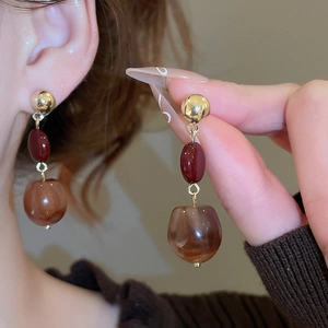 Detail view of retro three-tier dangle earrings with gold metal and marble texture beads