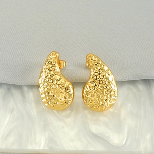Textured gold comma earrings featuring hammered wave patterns and irregular water drop shape