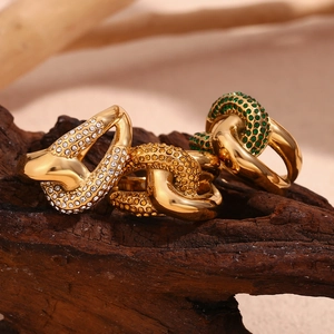 Three 18K gold plated knotted rings with clear, yellow, and green zircon on wood