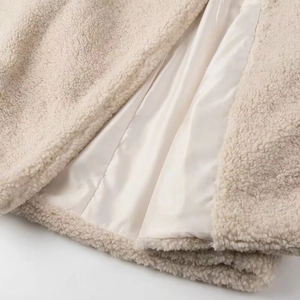 Detailed close-up of cream faux lamb wool fabric with high-quality inner lining texture