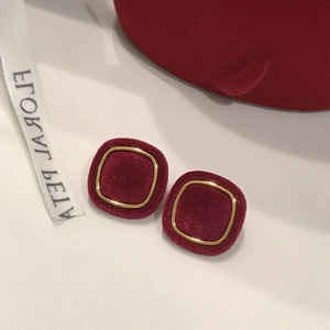 Detailed view of red velvet square stud earrings with elegant gold metallic borders
