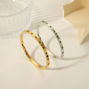 Minimalist gold and silver stainless steel bangles set with square emerald green stones