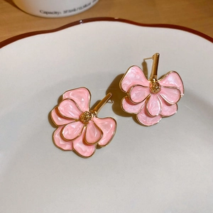 Detail of pink ginkgo leaf flower earrings with gold accents in a ceramic tray