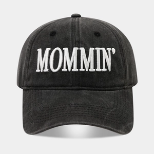 Close-up of white 3D MOMMIN embroidery on a washed cotton charcoal baseball cap