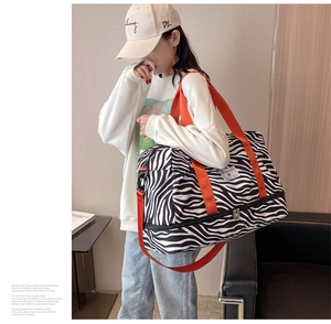 Vue détaillée du sac de voyage zébré avec sangles orange et compartiment à chaussures