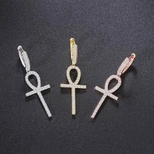 Gold and silver Ankh cross drop earrings with full zircon stones on dark background