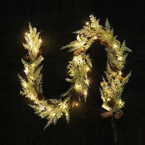 Artificial Christmas pine garland with snowy needles, pinecones, and warm LED fairy lights