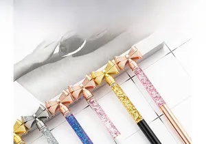 Close-up of glitter bow-knot ballpoint pens with liquid sand decor and metallic finish