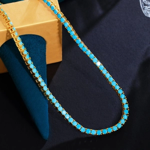 Macro shot of 3mm turquoise stone tennis chain on brass gold base and blue velvet box
