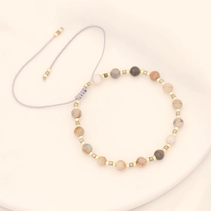 Detail of handmade beaded bracelet with natural stones and adjustable braided cord