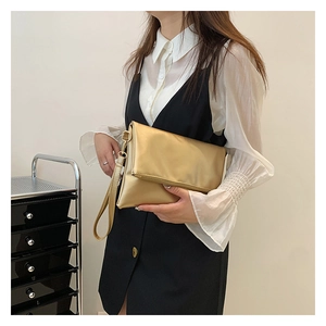 Primer plano de un elegante bolso de mano dorado metalizado para fiestas y eventos nocturnos