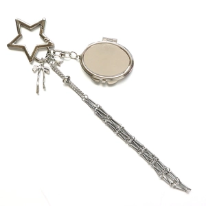 Silver metal keychain with star clasp, bow charm, and oval pendant with long tassel