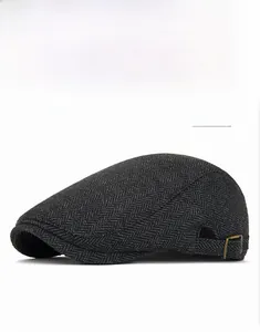 Dettaglio della fibbia metallica regolabile su coppola in tweed spinato grigio scuro