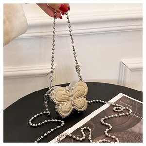 Detailed close-up of a silver butterfly shaped metal mini box bag with bead chain strap