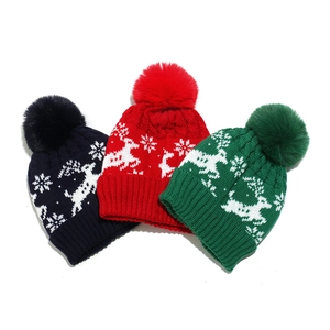 Détail de bonnets en tricot avec motifs de renne et flocons de neige et pompons en fourrure