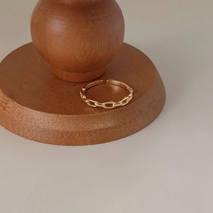 Minimalist S925 sterling silver golden chain open ring shown on a wooden stand