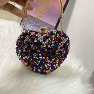 Detailed view of heart-shaped evening bag with multicolor rhinestones and gold chain