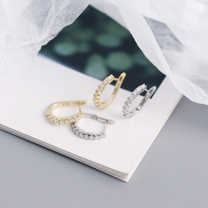 Detailed view of gold and silver S925 sterling silver U-shaped earrings with CZ stones