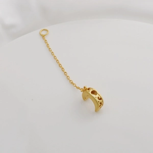 Detailed close-up of 18K gold-plated crescent moon pendant with fine link chain on white