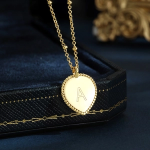 Macro shot of gold S925 sterling silver heart pendant necklace with letter A engraving