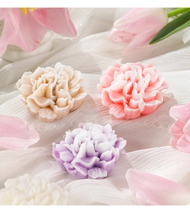 Top view of handmade carnation flower candles in soft pink, purple and white wax colors