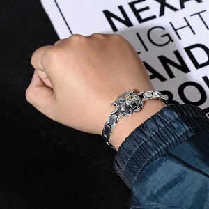 Close-up of a silver tiger head chain bracelet worn on a wrist for a bold masculine look