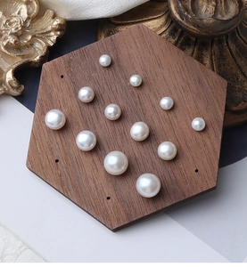 Detailed view of various sizes of white natural freshwater pearls on a wooden display stand
