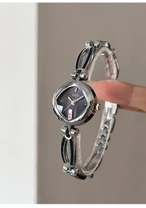 Detailed macro view of the silver bracelet watch featuring black enamel links and GEDI dial