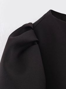 Close-up of black woven fabric texture with puff sleeve and pleated shoulder stitching