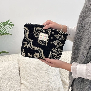 Detailed texture of black and white plush cosmetic bag with colorful dot pattern
