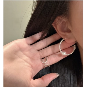 Detailed view of silver beaded hoop earrings with white pearl and a matching layered ring