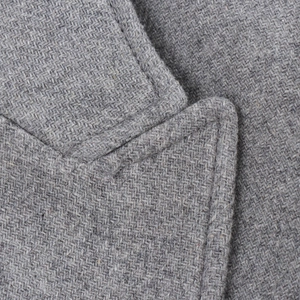 Close-up detail of grey wool coat collar showing fine weave texture and neat stitching