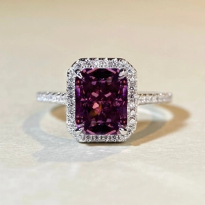 Macro shot of silver cushion cut fuchsia gemstone ring with halo diamond accents