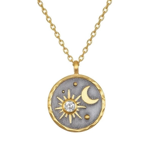Detailed macro of gold sun and moon coin pendant with sparkling cubic zirconia stone