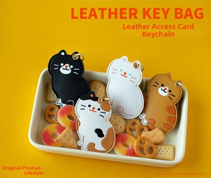 Détail des porte-clés en cuir en forme de chat pour badge d'accès et clés de voiture