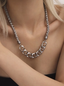 Detailed close-up of silver interlocking D-ring and twisted rope chain necklace on model