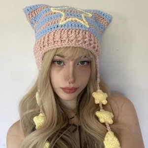 Detail of handmade crochet cat ear hat with blue pink stripes and yellow star charms