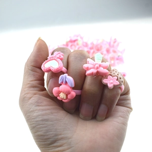 Close-up of pink plastic rings for girls featuring flower and strawberry shapes
