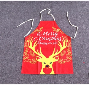 Detail of red Christmas apron with yellow reindeer print and festive holiday greetings