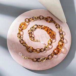 Detail of tortoise shell acrylic chain links and gold rings with silicone connectors